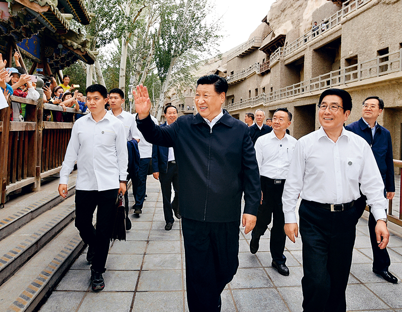 2019年8月19日至22日,中共中央总书记、国家主席、中央军委主席习近平在甘肃考察。这是19日下午,习近平在敦煌莫高窟考察调研时,向正在参观的游客亲切招手致意。 新华社记者 谢环驰/摄
